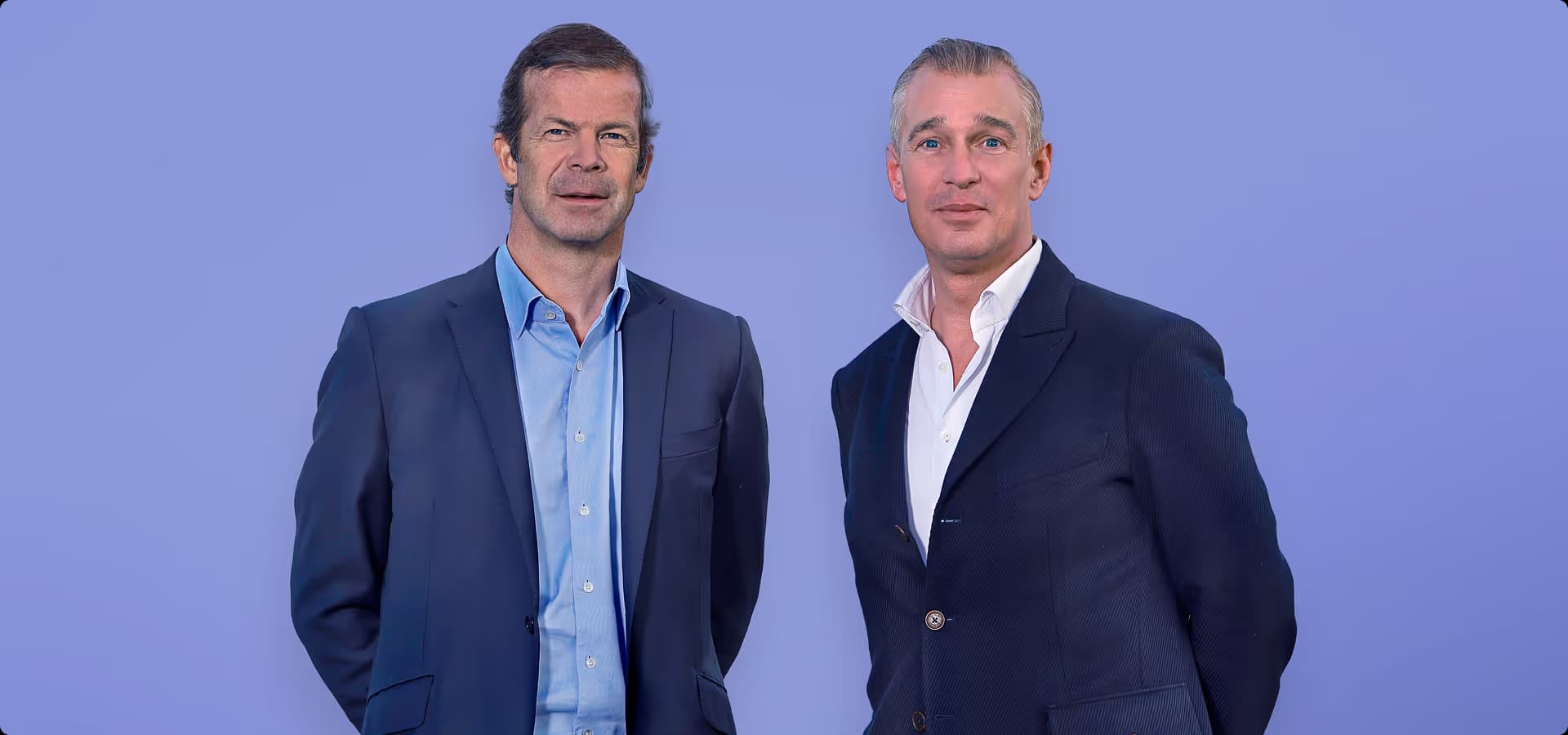 H.S.H. Prince Max von und zu Liechtenstein and Christian Schneider-Sickert standing in suits against a blue background