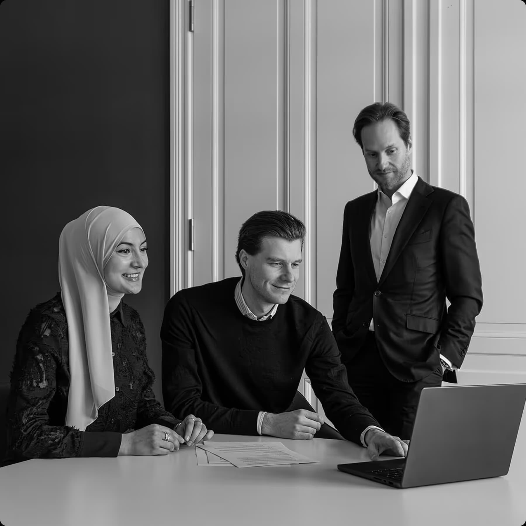 ZUWAX business team in black and white with a laptop and documents