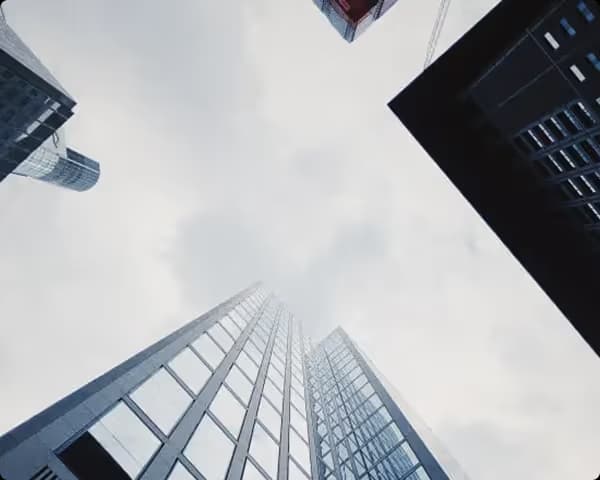 Skyscrapers from below, modern glass façades in a grey-blue perspective